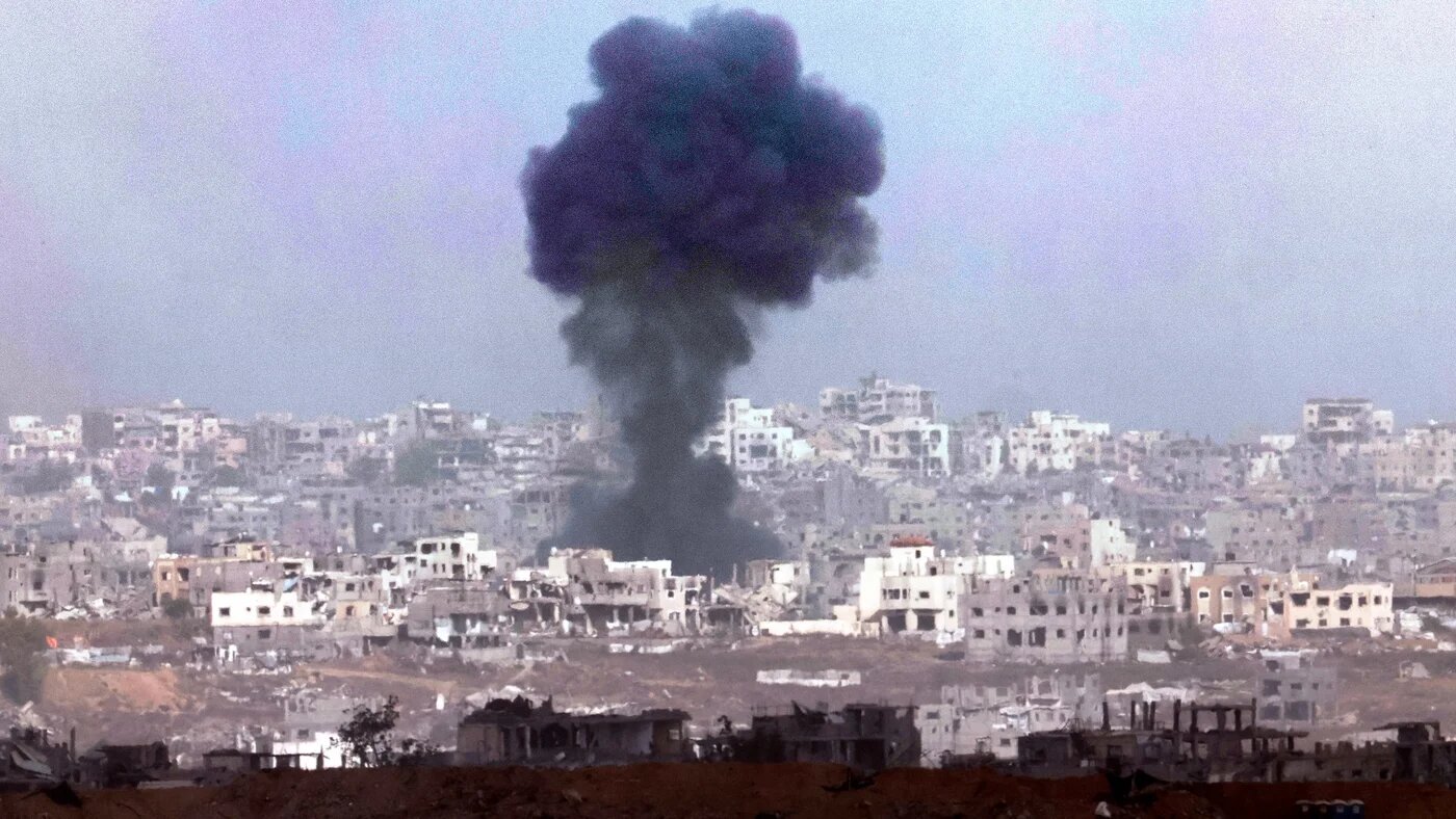 This picture taken from a position in southern Israel, shows smoke billowing above destroyed buildings during Israeli bombardment in the besieged Gaza Strip on 27 May 2025 (AFP/Jack Guez)