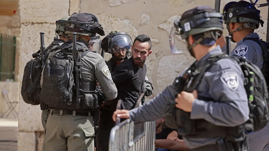 Israeli security forces detain a man at the entrance of Jerusalem's al-Aqsa mosque on 21 May 2021