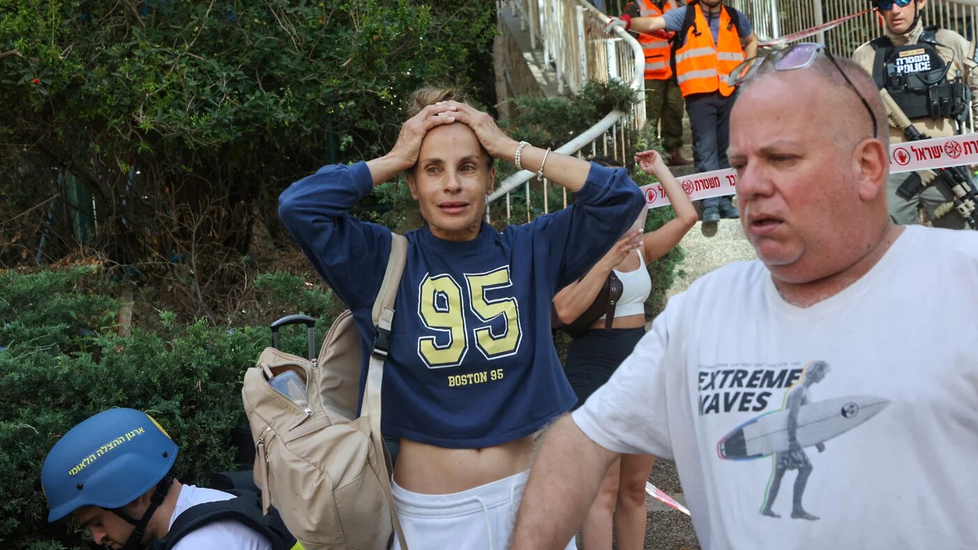 Civilians react as Israeli emergency services arrive at the site of an Iranian missile attack in Ramat Gan in central Israel near Tel Aviv, on 19 June 2025 (AFP)