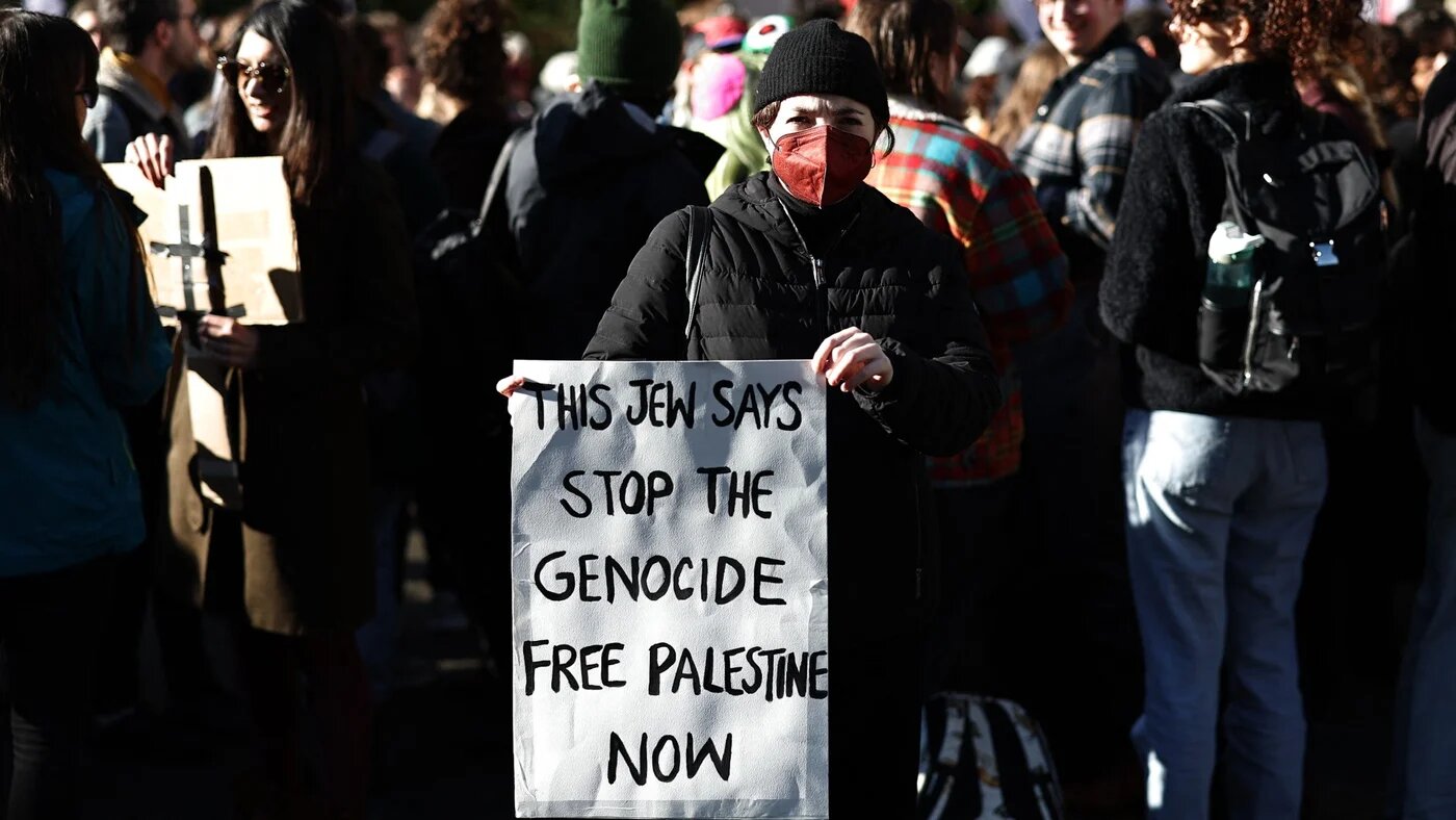 A protester holds a placard at a demonstration organised by Jewish Bloc, Jews For Palestine in central London on 11 November 2023 (AFP/Henry Nicholls)