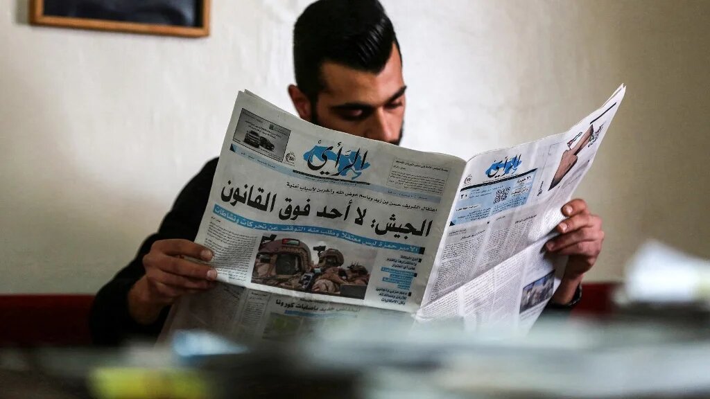 A Jordanian man reads a local newspaper in the capital Amman, on 4 April, 2021, with the headline: 'Army: No one is above the law' (AFP)