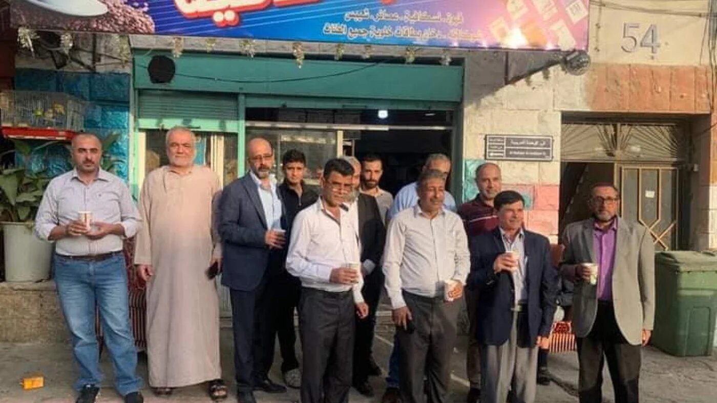 Des activistes politiques devant le café de Kameel al-Zoubi dans le quartier de Ramtha, réunis pour acheter des boissons en signe de soutien au propriétaire emprisonné (MEE/Jahid Abu Baidar)