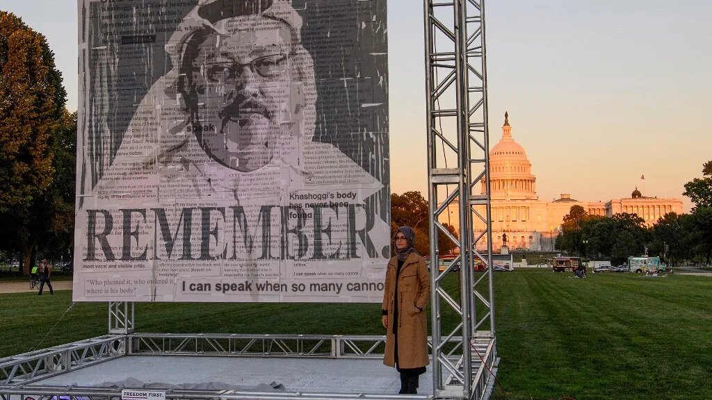 L’auteure turque Hatice Cengiz, fiancée du journaliste saoudien Jamal Khashoggi, pose à côté de son portrait à Washington, le 1er octobre 2021 (AFP)