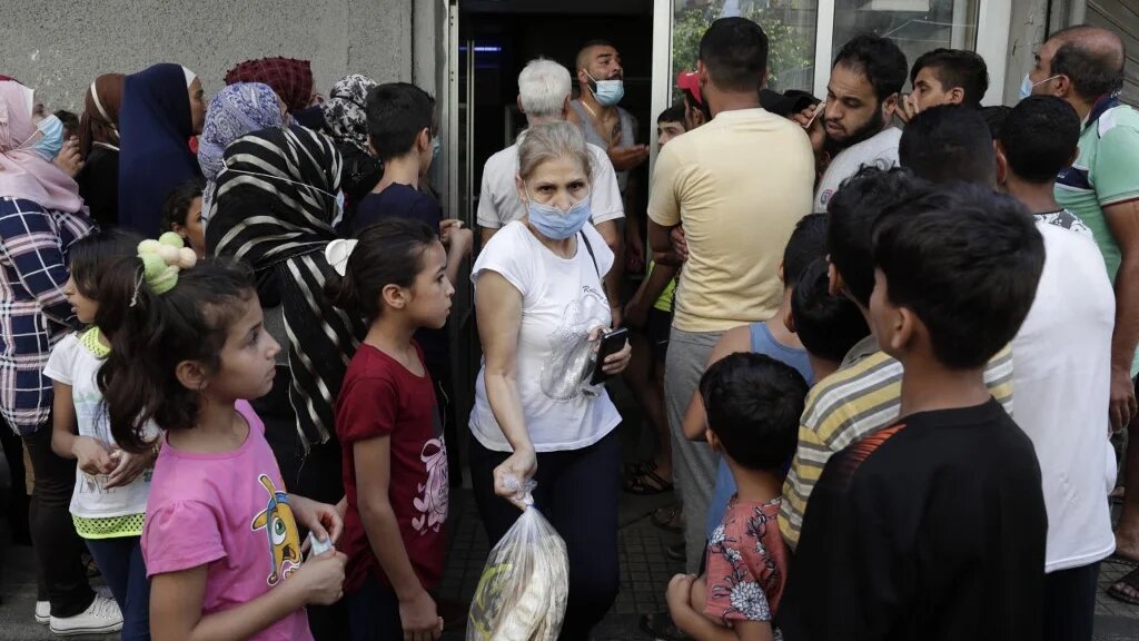 People wait in line at a bakery in the southern suburbs of Lebanon's Beirut on 13 August 2021, amidst a shortage of basic items due to a severe economic crisis.