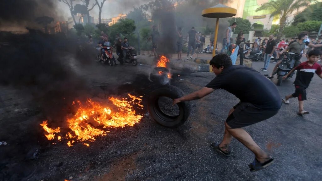 Lebanese youths burn tyres to block a main highway east of the capital Beirut, as they protest against the country's dire living conditions on 24 June 2021