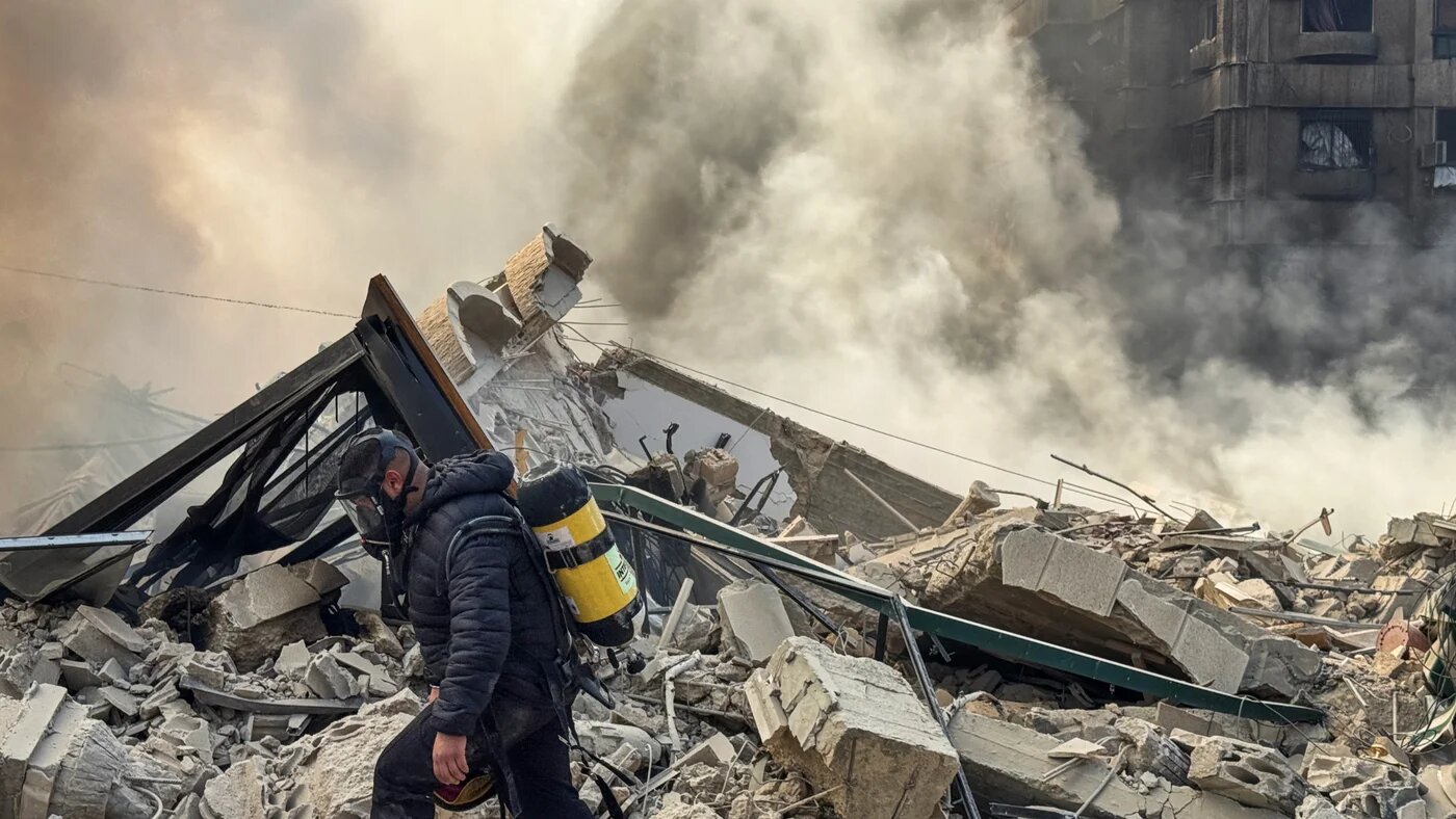 A firefighter inspects destruction at a site of an Israeli air strike in the southern suburbs of Beirut on 3 March 2026 (AFP)