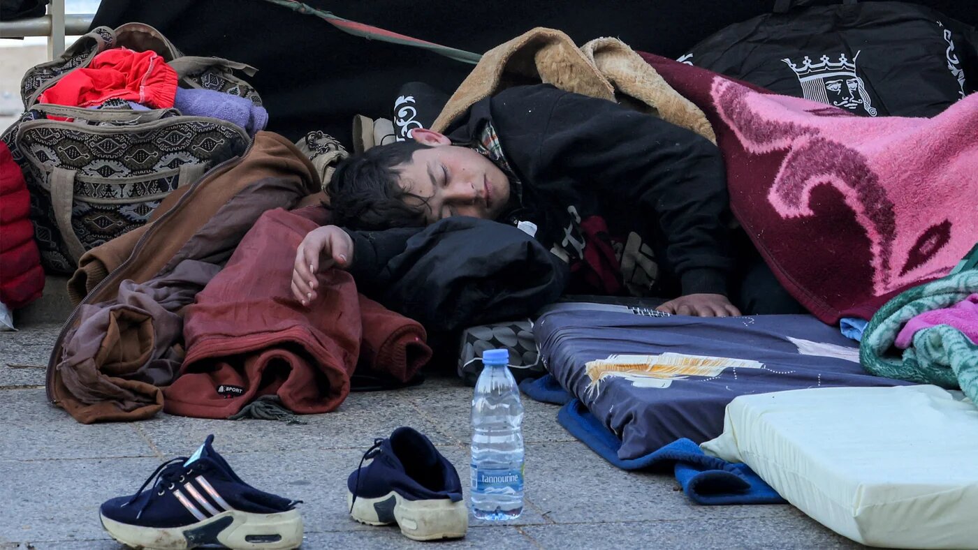 A child sleeps alongside family belongings in a makeshift encampment along the waterfront in Beirut on 10 March 2026 (AFP)