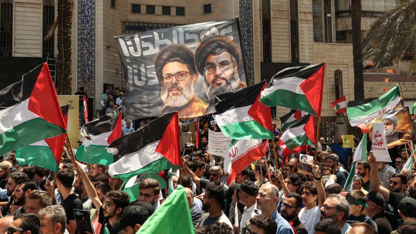 Hezbollah supporters wave Palestinian and Iranian flags in support of Iran  in Beirut's southern suburbs in June 2025 (AFP)