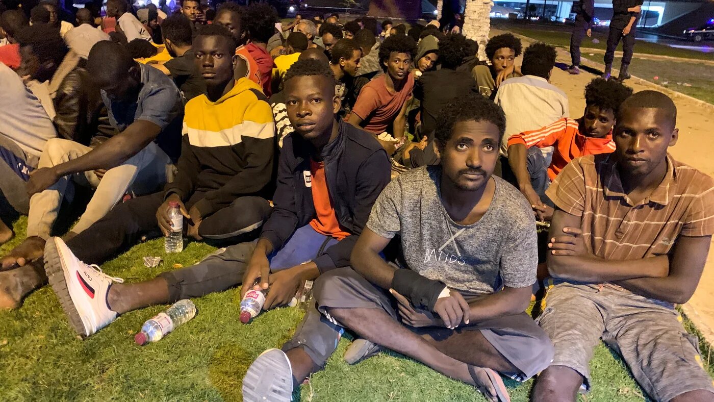 Migrants sit after they were detained by Libyan security forces in Tripoli, Libya on 8 October 2021