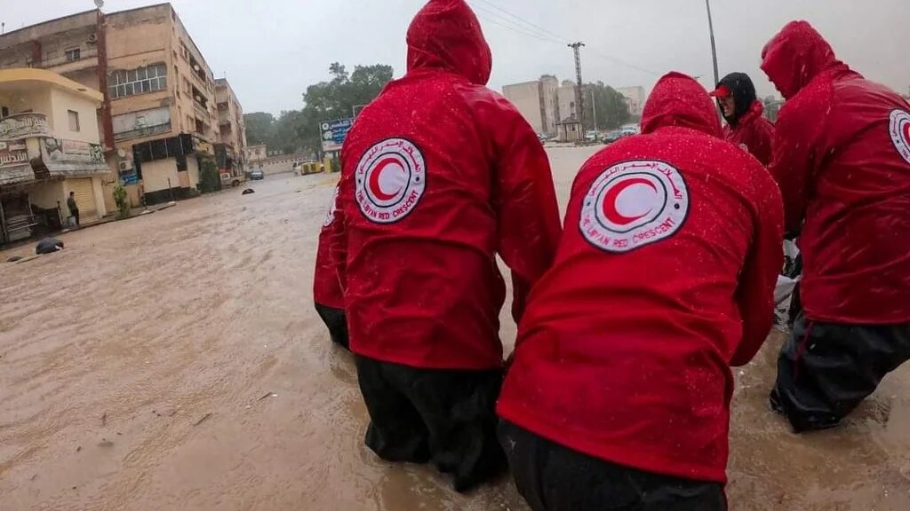 Members of the Libyan Red Crescent work on opening flooded roads in the city of al-Bayda in eastern Libya on 11 September