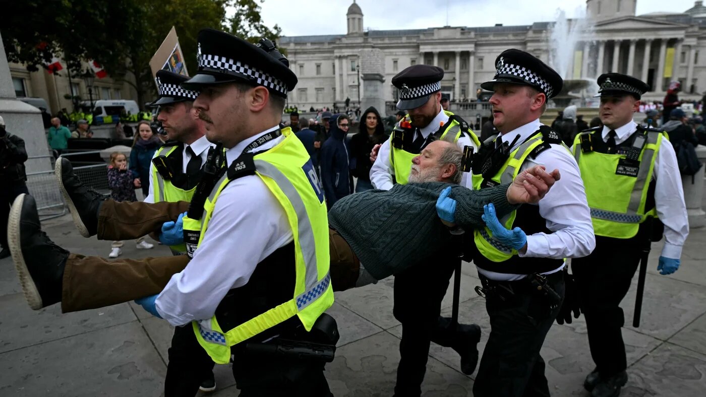A protester is taken away by police officers at a "Lift The Ban" demonstration in support of the proscribed group Palestine Action, calling for the recently imposed ban to be lifted, in central London, on 4 October 2025 (AFP/Justin Tallis)