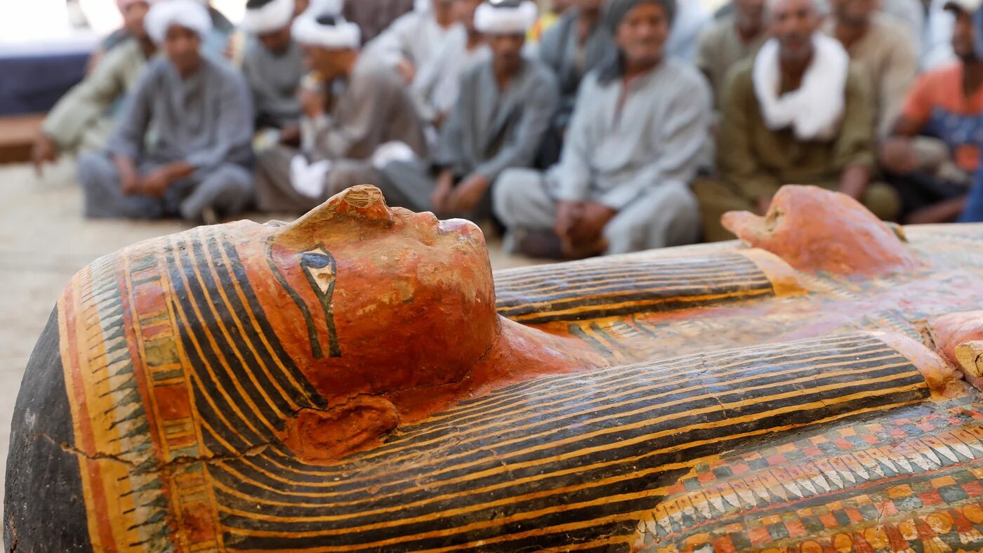 Excavators sit behind painted ancient coffins in the Valley of the Kings, Luxor (Reuters)
