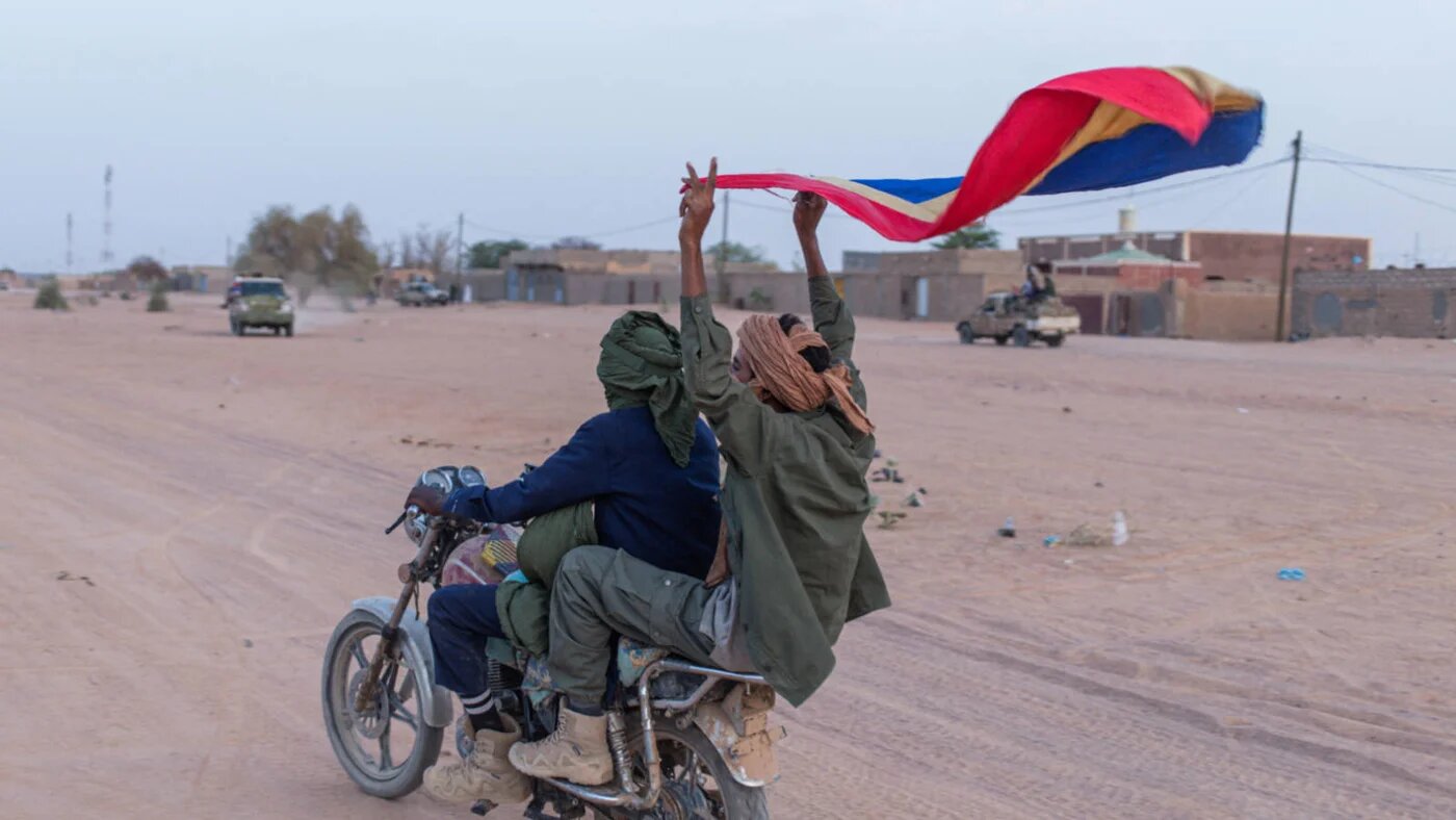 A soldier from the National Front for the Liberation of Azawad (FLA) waves an FLA flag in the streets of Kidal on 9 May 2026 (AFP).