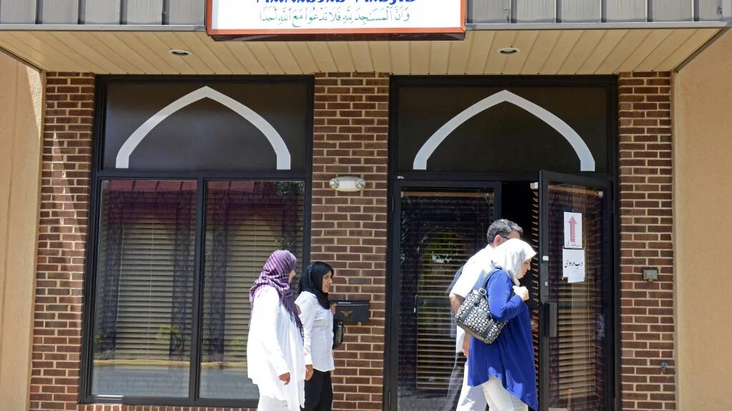 People pass one of the entrances of the Manassas Mosque in Manassas, Virginia.