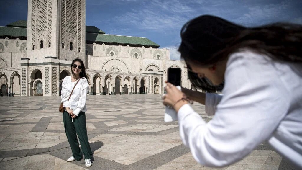 Des touristes se prennent en photo devant la mosquée Hassan II à Casablanca (AFP/Fadel Senna)