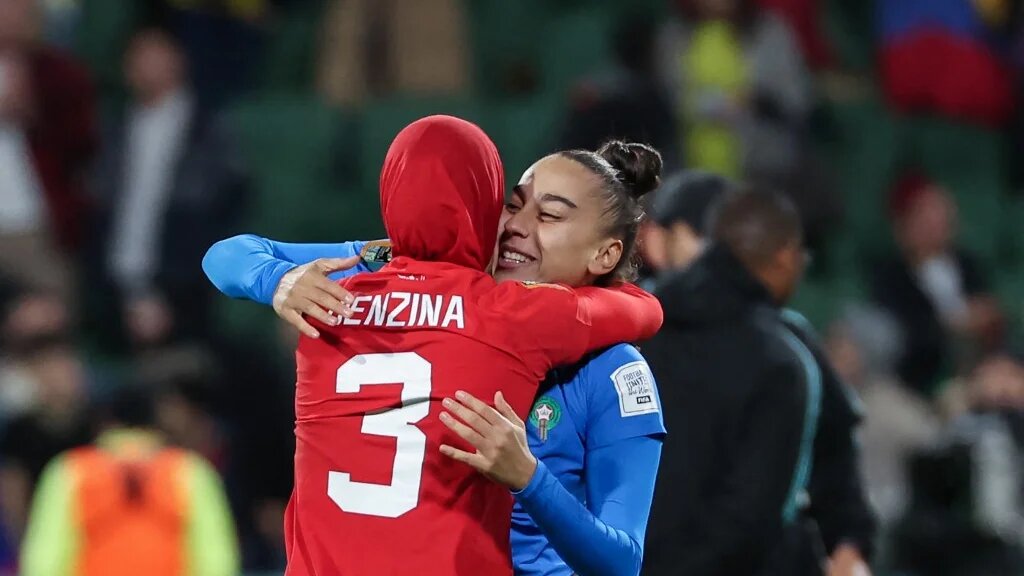 La défenseure marocaine Nouhaila Benzina (à gauche) embrasse la goal Ines Arouaissa alors que leur équipe vient de se qualifier pour les huitièmes de finale de la Coupe du monde féminine (AFP/Colin Murty)