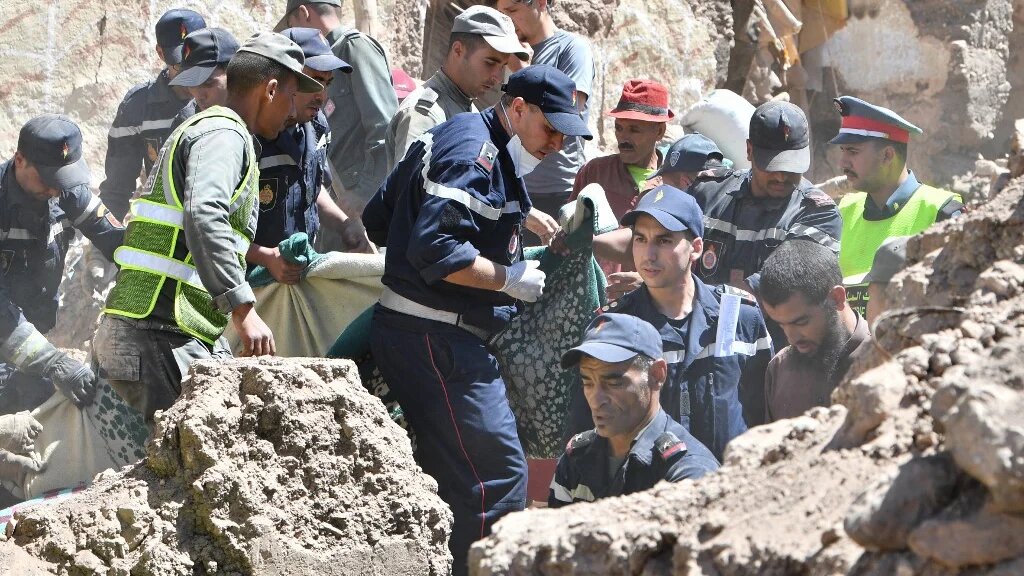 Les premiers secours retirent un corps des décombres à Tiksit, au sud de Marrakech, le 10 septembre 2023 (AFP/Fethi Belaïd)