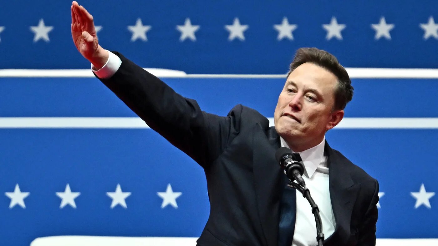 Tesla and SpaceX CEO Elon Musk salutes as he speaks during the inaugural parade inside Capital One Arena in Washington on 20 January 2025 (AFP)