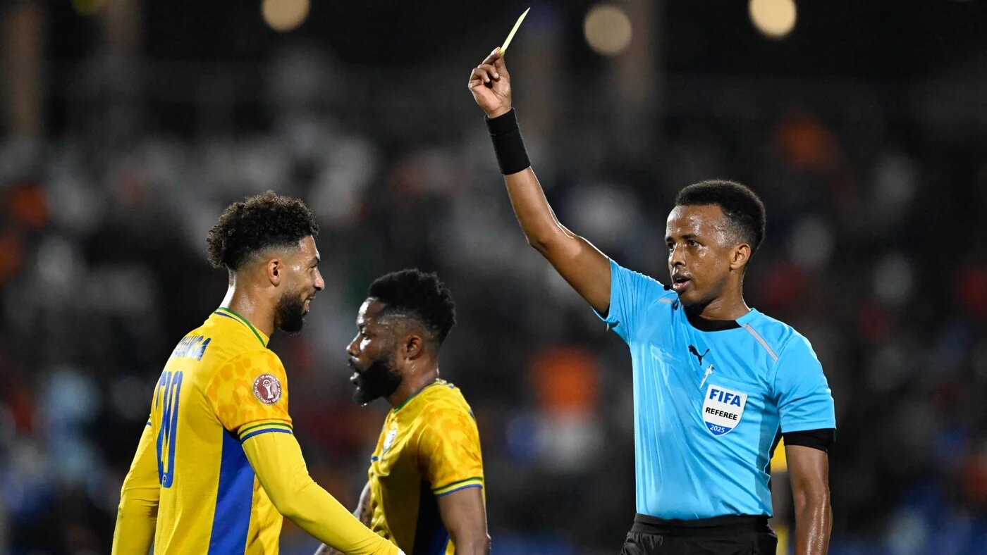 Gabon's forward Denis Bouanga is shown a yellow card by Somali referee Omar Abdulkadir Artan in Marrakech on 31 December 2025 (AFP/Khaled Desouki)