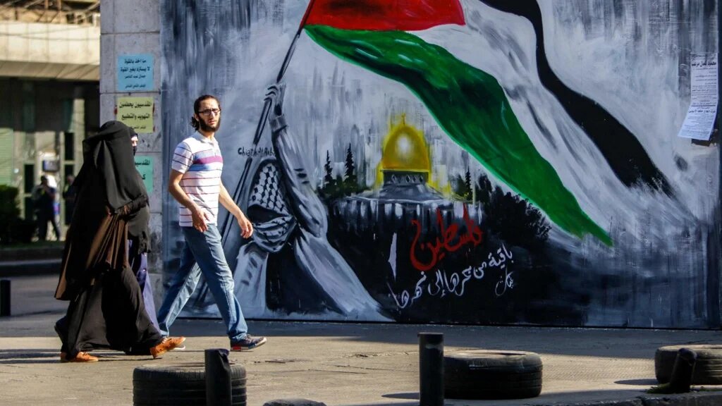 A mural reads “Palestine will remain, from the river to the sea” 