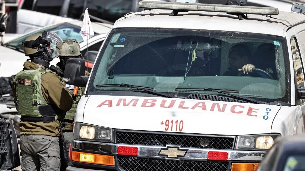 A Palestinian ambulance drives past Israeli forces in Kafr Aqab, south of Ramallah in the occupied West Bank, on 27 January 2026 (Zain Jaafar/AFP)
