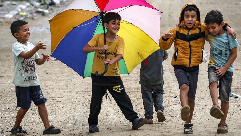 Children dance in the Bureij camp for Palestinian refugees, in the central Gaza Strip, on 1 October 2024 (Eyad Baba/AFP)