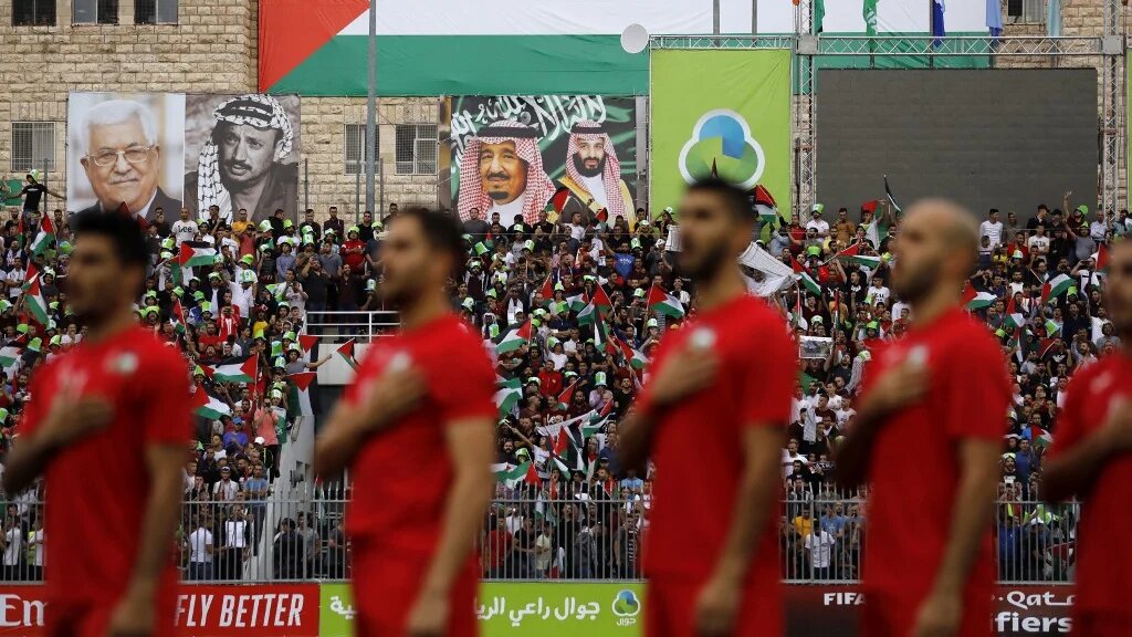 ​​​​​​​L’équipe nationale palestinienne de football chante son hymne national lors d’un match de qualification pour la Coupe du monde 2022 entre la Palestine et l’Arabie saoudite en Cisjordanie occupée, le 15 octobre 2019 (AFP/Ahmad Gharabli)
