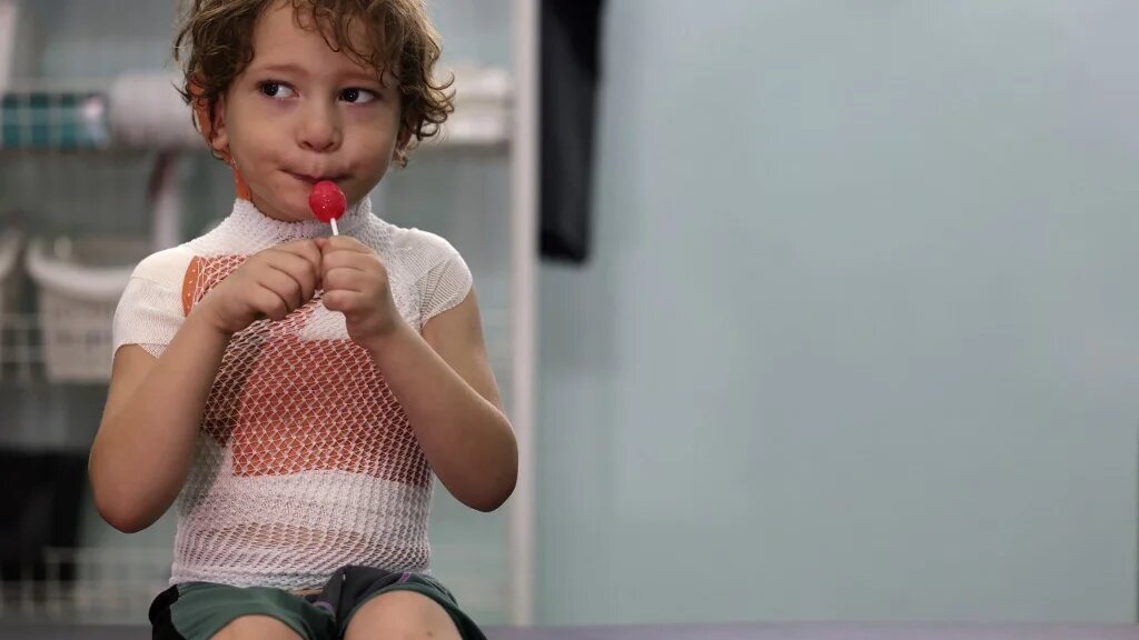 Yasser Khila, quatre ans, est réconforté avec une sucette après qu’un pansement a été appliqué sur ses brûlures, dans une clinique gérée par Médecins sans frontières (MSF) à Gaza le 7 septembre 2022 (AFP/Mohammed Abed)