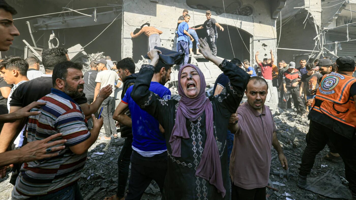 A Palestinian woman reacts as others rush to look for victims following an Israeli strike in Khan Yunis in the southern Gaza Strip on 17 October 2023 (AFP)