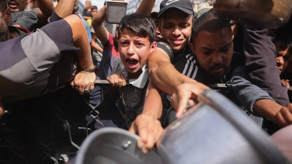 Palestinians jostle to get a portion of cooked food from a charity kitchen in Jabalia, in the northern Gaza Strip, on 17 May 2025 (Bashar Taleb/AFP)