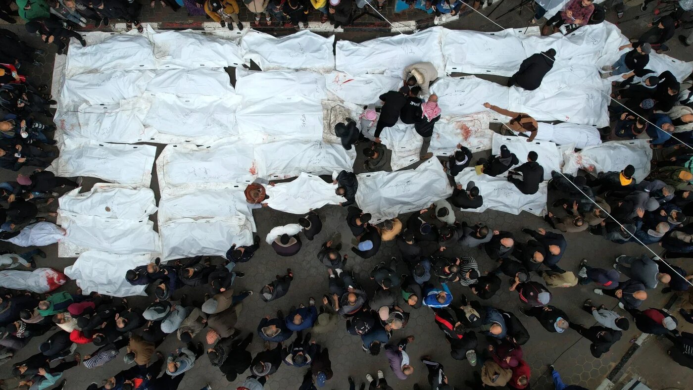 Une vue aérienne montre des Palestiniens pleurant leurs proches, le 25 décembre 2023, après une frappe israélienne visant le camp de réfugiés d’al-Maghazi, dans le centre de Gaza (AFP)