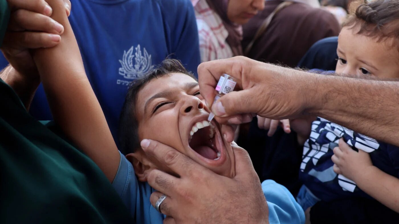 A health worker administers the polio vaccine to a Palestinian child in Zawayda, Gaza in September 2024 (AFP)