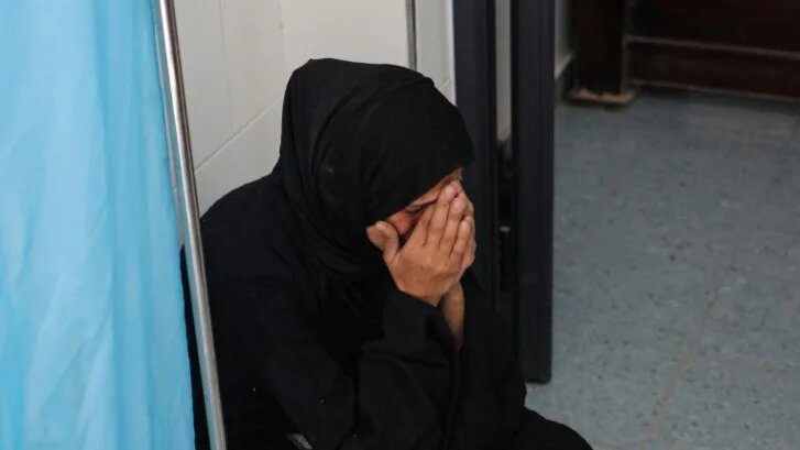 A woman reacts as her child receives medical attention for injuries sustained in an Israeli bombardment at a hospital in Rafah, Gaza, on 2 March 2024 (AFP)