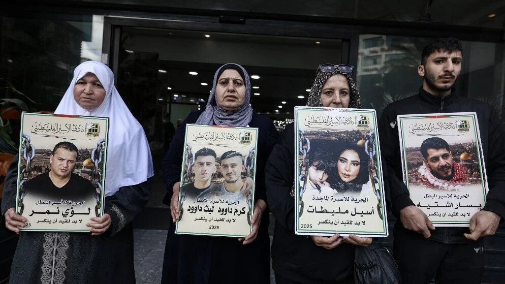 Relatives of Palestinian prisoners hold portraits during a demonstration against the death penalty law in Nablus, in the occupied West Bank, on 31 March 2026 (Jaafar Ashtiyeh/AFP)