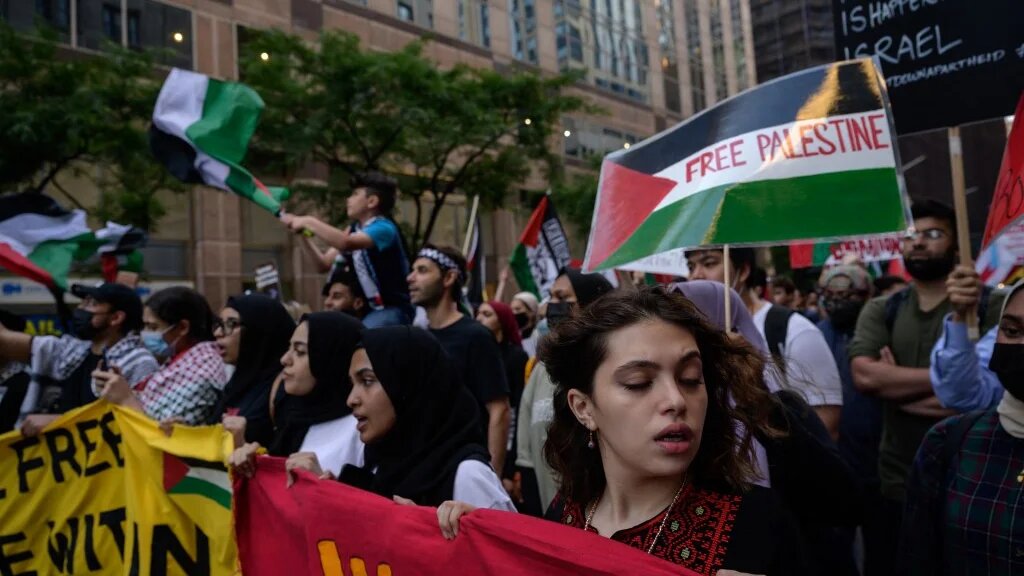 Demonstrators shout slogans and wave flags as they march during an 'emergency rally to defend Palestine' in Manhattan, New York on 15 June 2021.