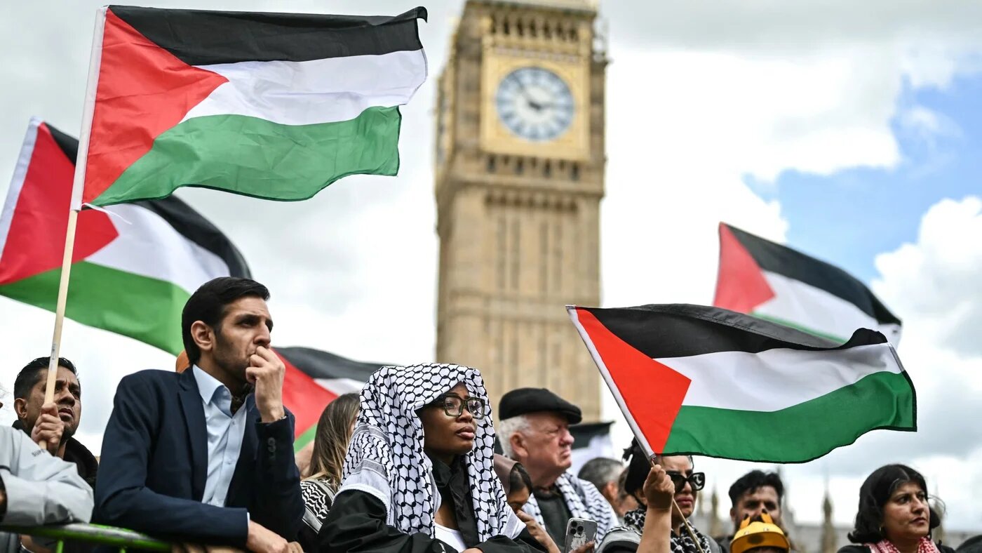 Protesters chant slogans and wave Palestinian flags as they stand in front Elizabeth Tower, commonly known by the name of the clock's bell "Big Ben", in central London, on 8 June 2024 (AFP/Justin Tallis)