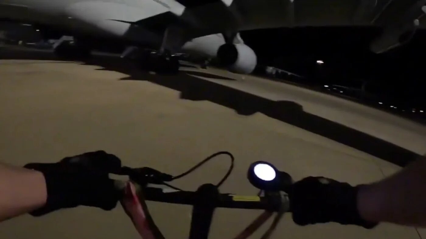 A Palestine Action activist approaches an RAF plane on an electric scooter (Palestine Action)