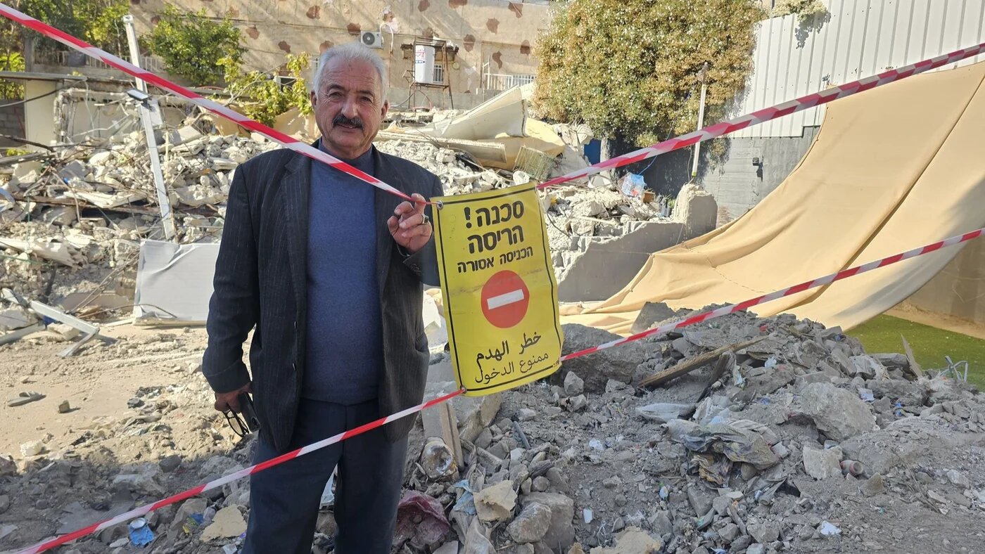 Fakhri Abu Diab, a local activist and resident of Silwan, located in Israeli-occupied East Jerusalem, stands beside the rubble of his demolished home (Provided)
