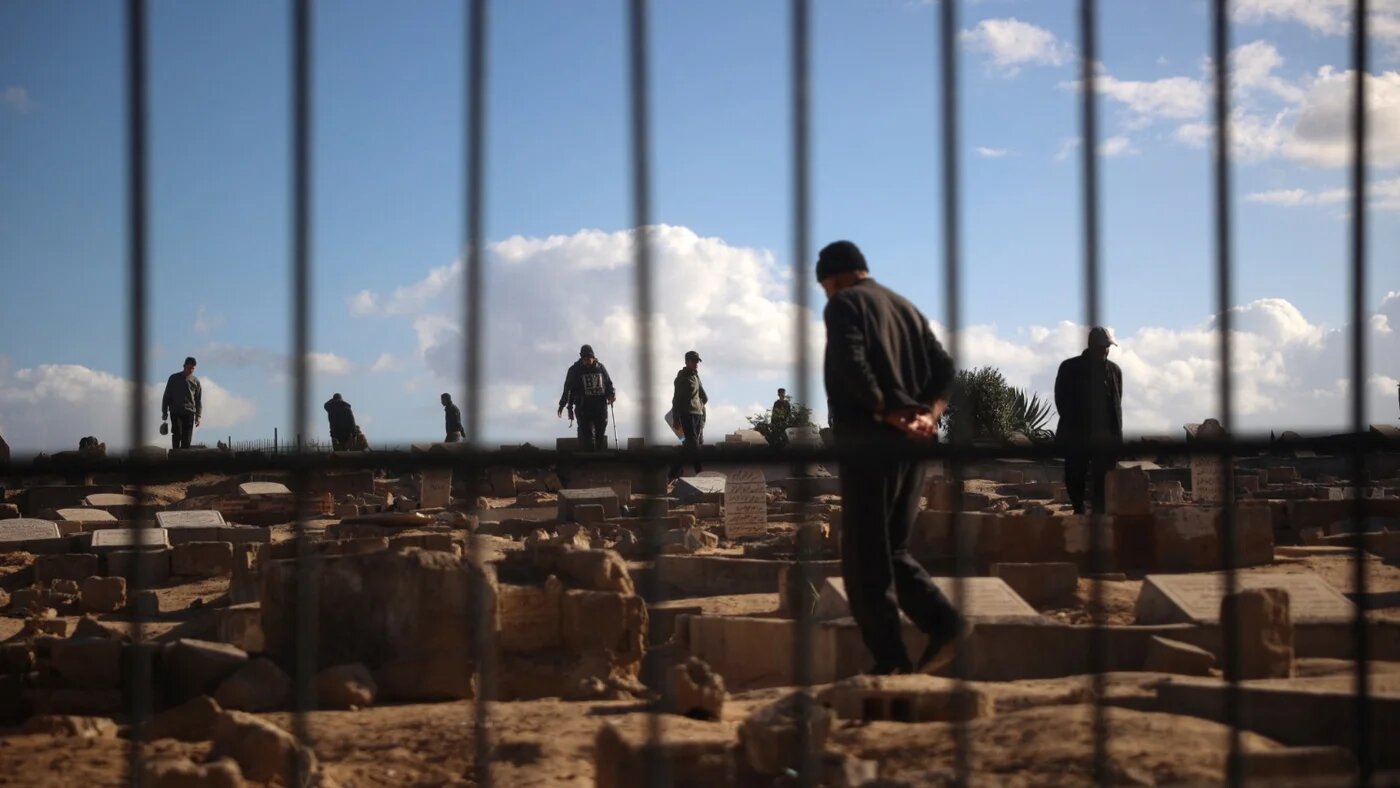 Palestinians inspect the damage at a cemetery after an Israeli airstrike on the Nuseirat refugee in the central Gaza Strip on 13 December 2024.
