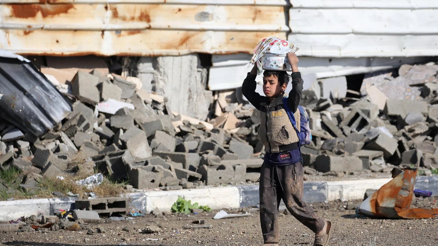 A Palestinian child carries a container on his head in al-Mughraqa, central Gaza Strip (AFP/Eyad Baba)