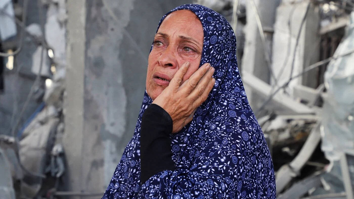 A Palestinian woman stands at the site of an Israeli strike in the Jabalia refugee camp, northern Gaza, 19 May, 2026 (Ebrahim Hajjaj/Reuters)