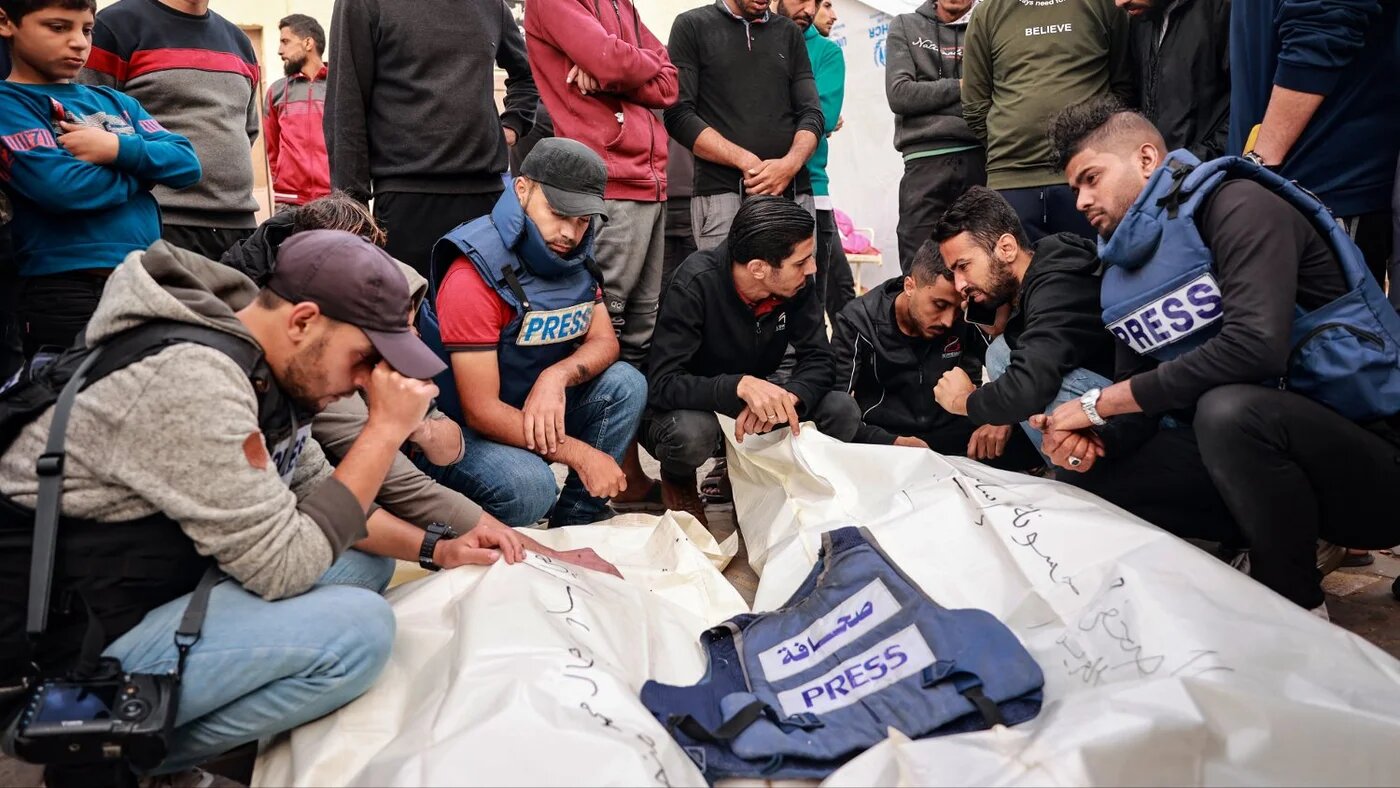 Friends and colleagues of two Palestinian journalists Hasouna Slim and Sari Mansoor, killed in an Israeli strike, mourn over their bodies during their funeral in Deir al-Balah in the southern Gaza Strip on 19 November 2023.