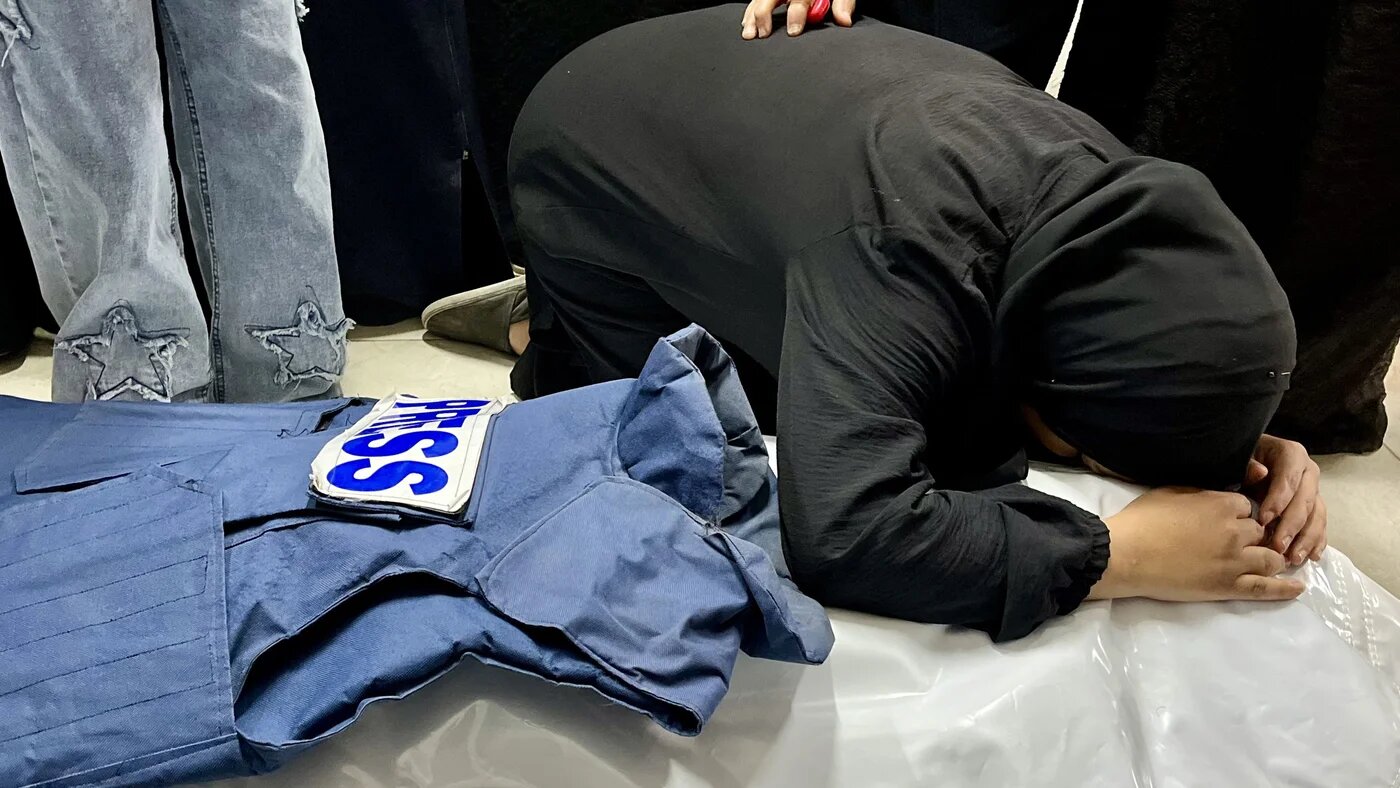 A woman mourns over the body of journalist Ahmed Mansour at Nasser Medical Complex in Khan Younis, south Gaza Strip, on 8 April, 2025 (AFP)