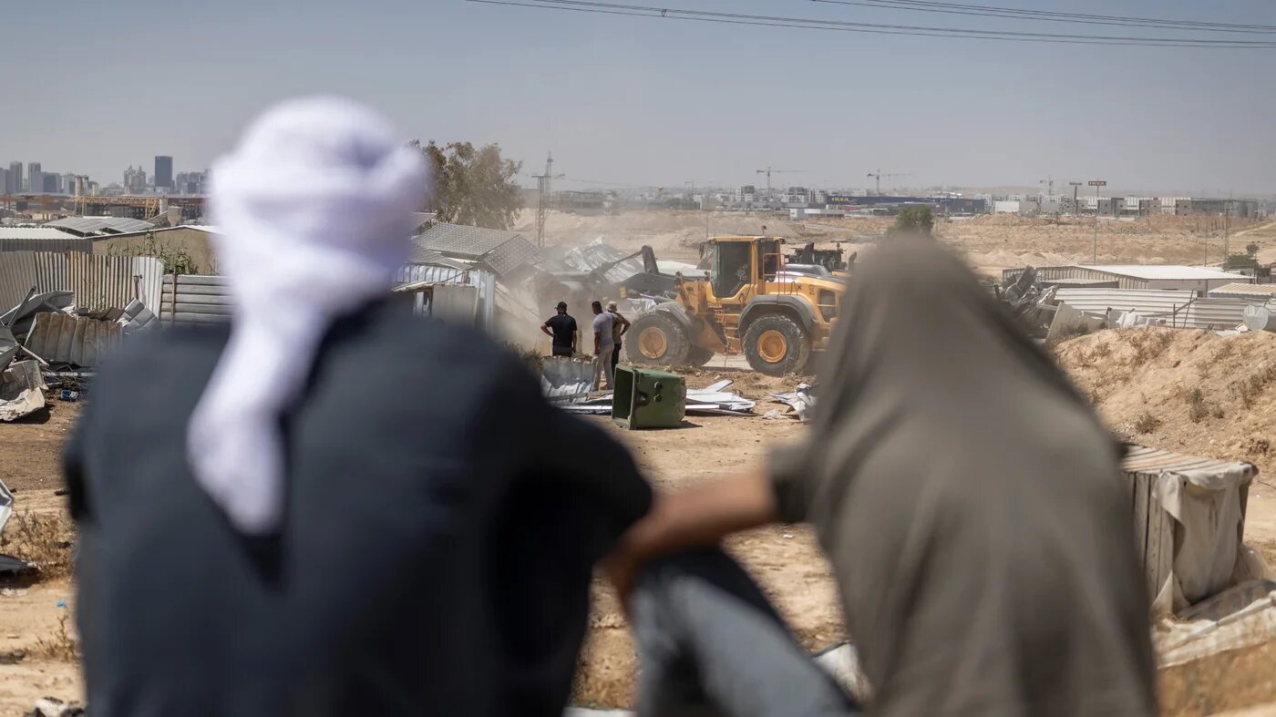 Bedouin look on as a family demolish their home after the Israeli authorities served demolition notices, ordering the owners to tear down their own premises or face being charged a hefty fee for the state to do it, in an al-Sir, a Bedouin village in the Negev, 16 June 2026 (AFP)