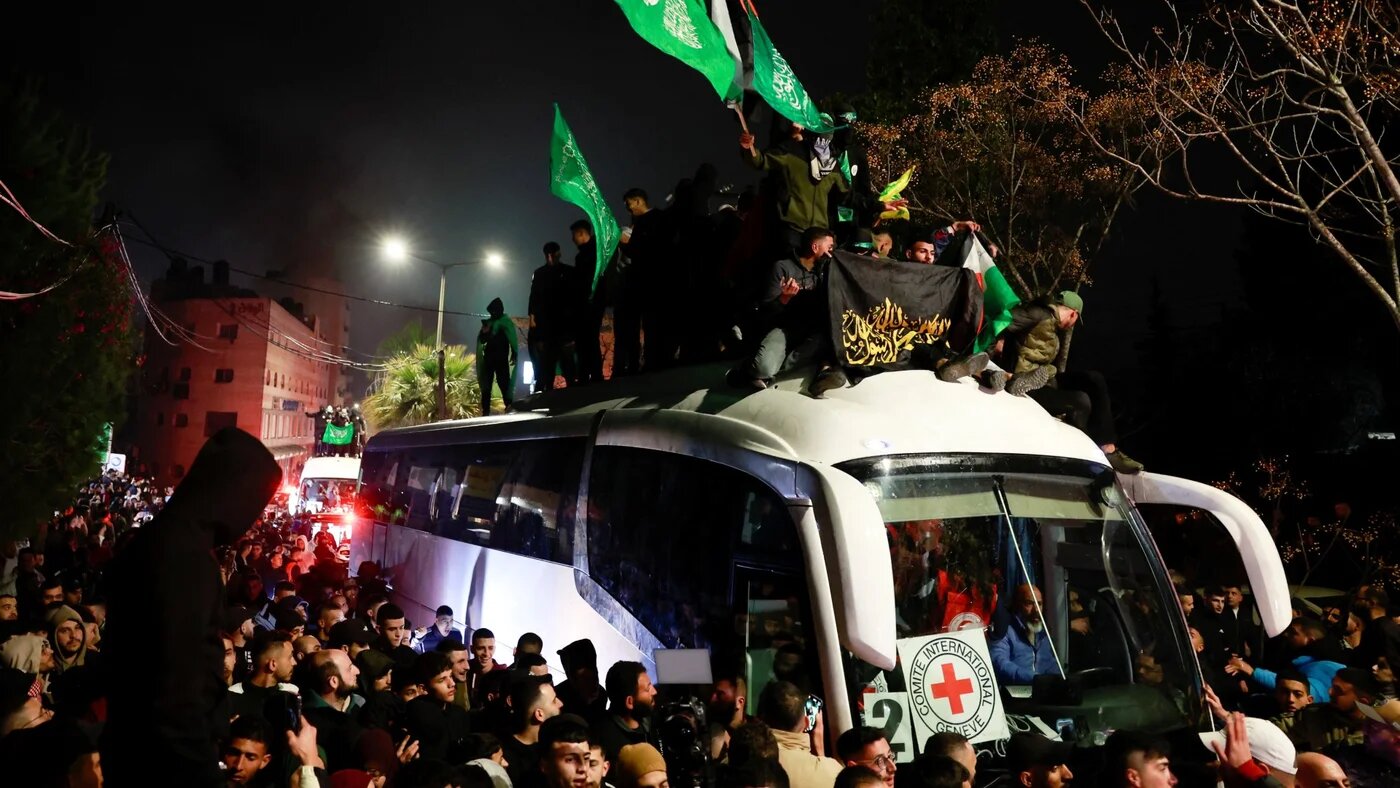 People gather around a bus carrying freed Palestinian prisoners near Ramallah, in the occupied West Bank on 20 January 2025 (Reuters/Ammar Awad)