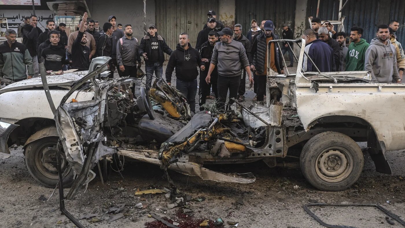 Palestinians gather around a destroyed police jeep that was targeted by an Israeli air strike in Nuseirat refugee camp, central Gaza Strip, on 22 March 2026 (AFP/Eyad Baba)