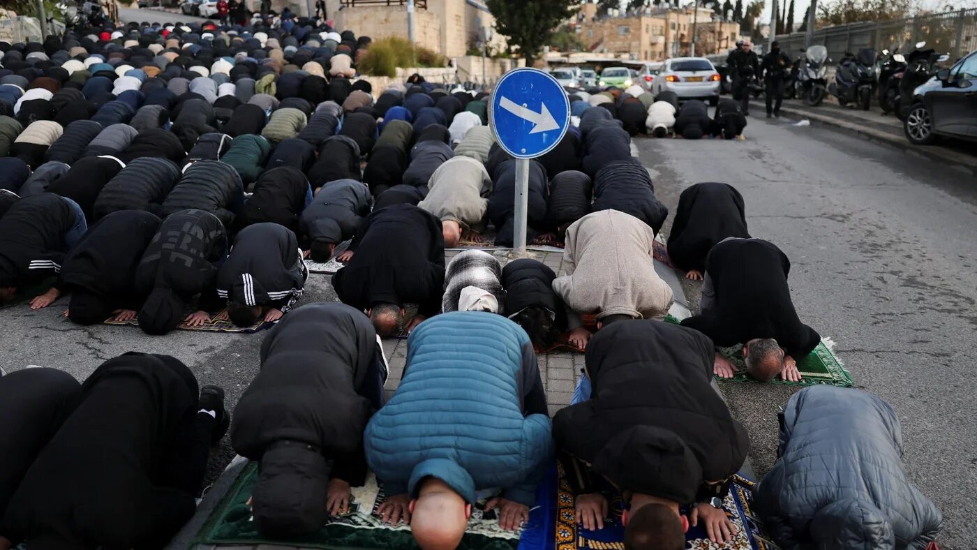 Muslim worshippers pray by a road to mark the end of the holy fasting month of Ramadan, as Israel barred them from Al-Aqsa Mosque complex, Jerusalem, 20 March 2026 (Ammar Awad/Reuters)