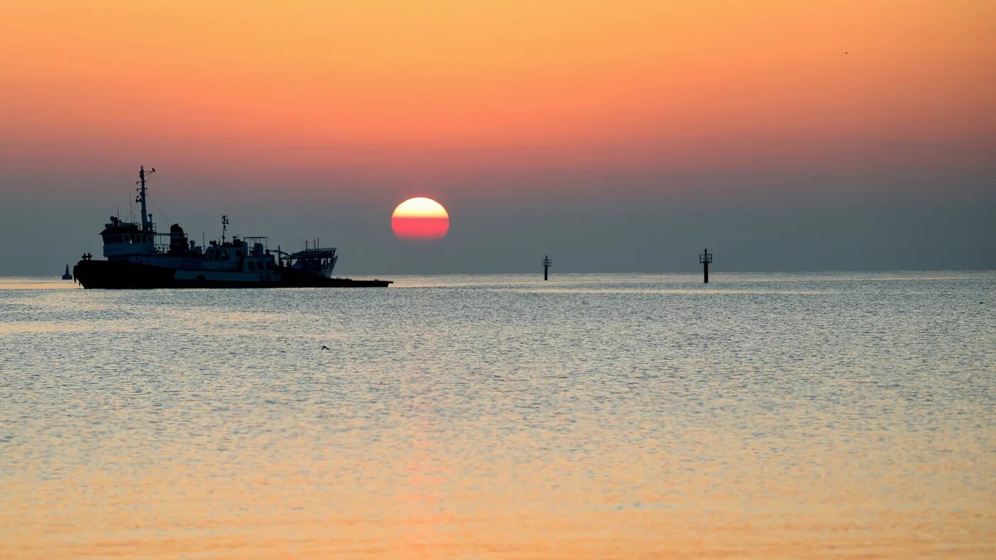 The sun rises over a boat on the Persian Gulf in Al Wakrah, some 30km from Doha, in November 2024 (AFP/Karim Jaafar)