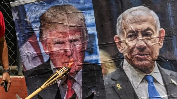 A man burns a picture of US President Donald Trump and Israeli Prime Minister Benjamin Netanyahu during an antiwar protest in the Philippines, on 9 April 2026 (Jam Sta Rosa/AFP)