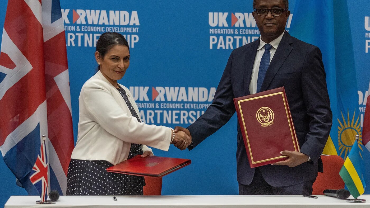 British Home Secretary Priti Patel and Rwandan Minister of Foreign Affairs and International Cooperation Vincent Biruta shake hands after signing an agreement in Kigali, Rwanda on 14 April 2022 (AFP)